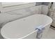 Close up of a freestanding bathtub with towel and marble surround near a window at 4128 Causeway Vista Dr, Tampa, FL 33615