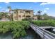 Exterior of a multi-story home showcasing the backyard, a wooden walkway, and lush foliage at 4128 Causeway Vista Dr, Tampa, FL 33615