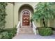 Arched front door with beautiful stairs and elegant landscaping at 4128 Causeway Vista Dr, Tampa, FL 33615