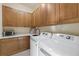 Well-organized laundry room featuring modern appliances and ample cabinet space at 4128 Causeway Vista Dr, Tampa, FL 33615