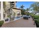 Outdoor pool area featuring a spiral staircase, wooden deck, lounge chairs and tropical landscaping at 4128 Causeway Vista Dr, Tampa, FL 33615
