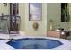Inviting backyard spa with tiled trim, lush greenery, and a decorative lion head accent on the exterior wall at 4128 Causeway Vista Dr, Tampa, FL 33615