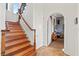 Staircase with wood steps and wrought iron railing leading to an arched entry with wine storage at 4128 Causeway Vista Dr, Tampa, FL 33615
