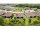 Wide aerial view of the home surrounded by a lush, green yard and neighborhood lake at 4155 Barletta Ct, Wesley Chapel, FL 33543
