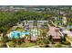 Aerial view shows a community pool, clubhouse, tennis courts, playground, and mature trees and landscaping at 4155 Barletta Ct, Wesley Chapel, FL 33543