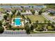 Aerial view of community pool and park area with lush landscaping, a lake, and well-maintained homes at 4155 Barletta Ct, Wesley Chapel, FL 33543