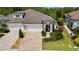 Eye-catching single-story home with a brick driveway, a three-car garage, and manicured landscaping at 4155 Barletta Ct, Wesley Chapel, FL 33543