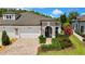 Beautiful single-story home featuring a brick driveway, three-car garage, and lush landscaping at 4155 Barletta Ct, Wesley Chapel, FL 33543