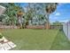 Spacious backyard featuring lush green grass, landscaping, and a wooden fence surrounding the perimeter at 4714 W Vasconia St, Tampa, FL 33629
