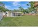 Backyard with lush green grass and a wooden fence, with a view of the house at 4714 W Vasconia St, Tampa, FL 33629