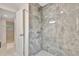 Modern bathroom shower featuring stylish marble tile, a rainfall showerhead, and sleek fixtures at 4714 W Vasconia St, Tampa, FL 33629