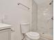 Bright bathroom featuring a toilet and a walk-in shower with white marble tiling and a rainfall shower head at 4714 W Vasconia St, Tampa, FL 33629