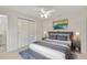 Comfortable bedroom featuring a large bed with grey bedding, a ceiling fan, and sliding closet doors at 4714 W Vasconia St, Tampa, FL 33629