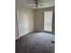 Bright bedroom showcasing plush carpeting, a ceiling fan, a window and a spacious closet at 4793 Pleasant Ave, Palm Harbor, FL 34683