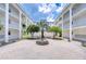 Beautiful courtyard featuring a fountain, chairs, mature trees, and a building with white columns and balconies at 4801 Airport Rd # 211, Zephyrhills, FL 33542