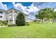 Well maintained building exterior with lush lawn and mature landscaping on a sunny day with a beautiful cloudy sky at 4801 Airport Rd # 211, Zephyrhills, FL 33542