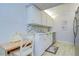 Kitchen with white cabinets, tiled backsplash, stainless steel dishwasher, and adjacent desk area at 4801 Airport Rd # 211, Zephyrhills, FL 33542