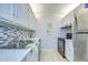 Kitchen features tile backsplash and flooring, stainless steel appliances, and white cabinets at 4801 Airport Rd # 211, Zephyrhills, FL 33542
