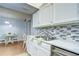 Bright kitchen featuring white cabinetry, a stainless steel sink and marble countertops at 4801 Airport Rd # 211, Zephyrhills, FL 33542