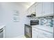 Kitchen featuring an oven range, white cabinets and marble countertops with tile backsplash at 4801 Airport Rd # 211, Zephyrhills, FL 33542