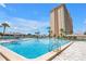 Relax by the pool with a view of the building and sunny skies at 4900 Brittany S Dr # 611, St Petersburg, FL 33715