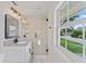 Bathroom featuring a glass shower, stylish vanity, modern fixtures, and a large window at 4918 Stolls Ave, Tampa, FL 33615