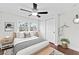 This staged bedroom offers a ceiling fan, hardwood floors, and lots of natural light from the window at 4918 Stolls Ave, Tampa, FL 33615