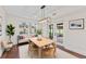 Cozy dining room boasts wood floors, a modern light fixture, and outdoor views from the glass doors at 4918 Stolls Ave, Tampa, FL 33615