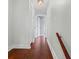 Hallway with hardwood floors, a decorative light fixture, and access to other rooms at 4918 Stolls Ave, Tampa, FL 33615