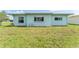 View of the backyard with green grass and a view of the home's rear at 5377 Springwood Blvd, Pinellas Park, FL 33782