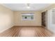 Bright bedroom featuring hardwood floors, a ceiling fan, and an expansive window for natural light at 5377 Springwood Blvd, Pinellas Park, FL 33782