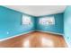 Vibrant bedroom with hardwood floors and two windows letting in plenty of natural light at 5377 Springwood Blvd, Pinellas Park, FL 33782