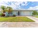 Charming single-story home featuring a well-maintained lawn, palm trees, and a clean, attached garage at 5377 Springwood Blvd, Pinellas Park, FL 33782