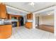 Bright kitchen featuring black appliances, honey-toned cabinets, and tiled floor, opening to a sunny bonus room at 5377 Springwood Blvd, Pinellas Park, FL 33782