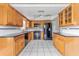 Traditional kitchen with black appliances, honey-toned cabinets, and tiled floor creates a warm and inviting space at 5377 Springwood Blvd, Pinellas Park, FL 33782