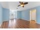 Bright living room with wood floors, ceiling fan, and a front door leading to the home's entryway at 5377 Springwood Blvd, Pinellas Park, FL 33782
