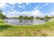 Scenic view of the pond with stone edging, lush grass, and surrounding trees at 5377 Springwood Blvd, Pinellas Park, FL 33782