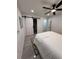 Bright bedroom with a modern ceiling fan, white bedding, and stylish rug at 539 Freeport N Ave, St Petersburg, FL 33702