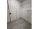 Walk-in closet with white door, baseboards, and modern gray tile at 539 Freeport N Ave, St Petersburg, FL 33702