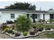 Charming single-story home featuring a white exterior, black accents, and meticulously landscaped front yard at 539 Freeport N Ave, St Petersburg, FL 33702