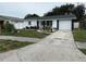 Well-maintained home with a white exterior, dark trim, and a concrete driveway at 539 Freeport N Ave, St Petersburg, FL 33702