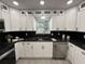 Modern kitchen with white cabinets, black countertops, and stainless steel appliances at 539 Freeport N Ave, St Petersburg, FL 33702