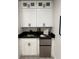 Wet bar featuring white cabinets, a mini-fridge, and a black countertop with a sink at 539 Freeport N Ave, St Petersburg, FL 33702