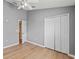 Bedroom features wood-look flooring, ceiling fan, closet and access to additional rooms at 589 52Nd N Ave, St Petersburg, FL 33703