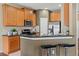 Open-concept kitchen featuring wood cabinets, granite counters, stainless appliances, and a breakfast bar at 589 52Nd N Ave, St Petersburg, FL 33703