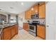 Bright kitchen with stainless steel appliances, wood cabinets, tile floors, and a view to the outside at 589 52Nd N Ave, St Petersburg, FL 33703