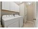 Laundry room with white washer and dryer units, white cabinets, and tiled flooring at 589 52Nd N Ave, St Petersburg, FL 33703