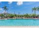Inviting community pool with clear blue water, palm trees, waterfall feature, and comfortable lounge chairs at 589 52Nd N Ave, St Petersburg, FL 33703