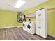 Large laundry room featuring a modern washer and dryer set, storage cabinets, and wood-style flooring at 6361 92Nd N Pl # 1704, Pinellas Park, FL 33782