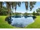 Backyard view of pond with mature trees covered in spanish moss and well-maintained landscaping at 6621 Appaloosa Dr, Tampa, FL 33625